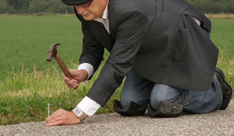 man met hamer en spijker op de weg 